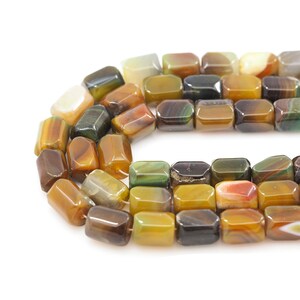 May include: A strand of colorful agate beads, each bead is a rectangular shape with a faceted edge. The beads are a mix of brown, green, yellow, and orange colors.