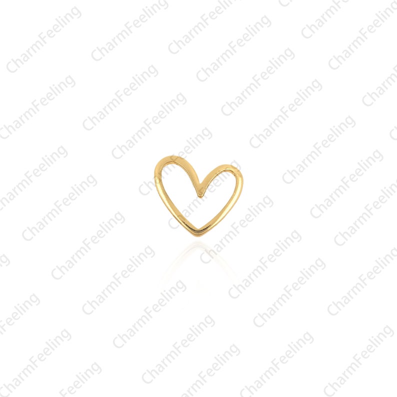May include: A gold-colored heart-shaped charm. The charm is a simple, open heart design.