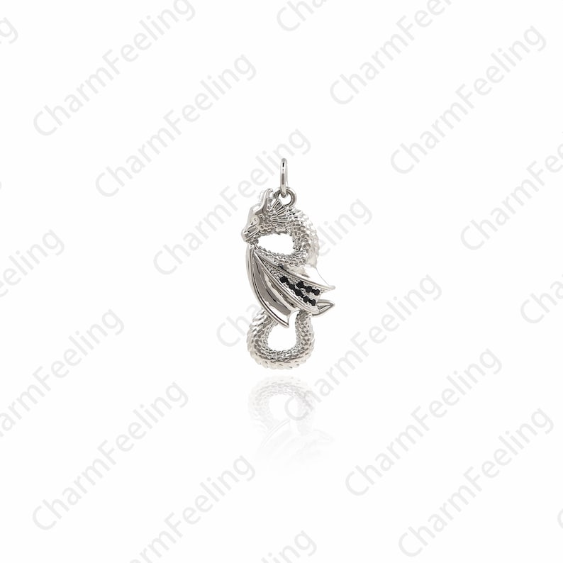 May include: Silver dragon pendant with black accents. The dragon is curled up with its wings spread out.