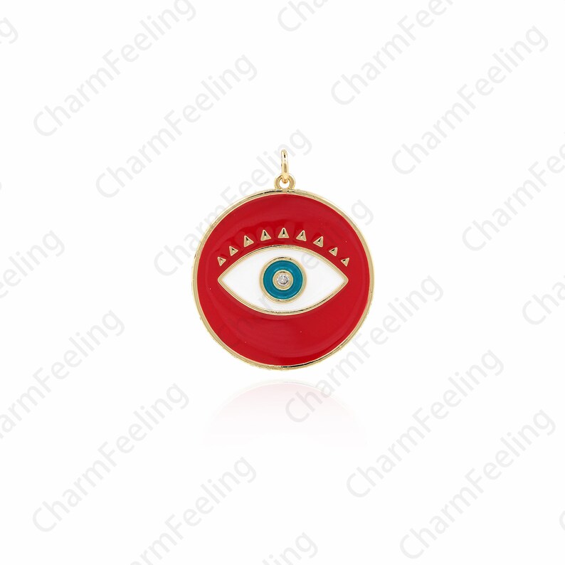K&ouml;nnte beinhalten: Ein roter, wei&szlig;er und blauer Email-Anh&auml;nger mit goldfarbenem Rahmen. Der Anh&auml;nger zeigt ein stilisiertes Auge mit einer blauen Pupille und einer wei&szlig;en Iris. Das Auge ist von einem Ring aus kleinen Dreiecken umgeben.