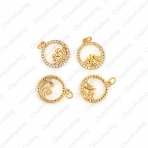May include: Four gold-tone metal charms with a circle design. Each charm features a different design: a wave, a mountain, a wave, and a mountain. The charms are adorned with clear rhinestones.