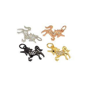 May include: Four unicorn charms in different finishes: silver, rose gold, gold, and black. Each charm features a detailed unicorn design with sparkling rhinestones.