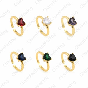 May include: Set of ten gold adjustable rings with heart-shaped stones. The stones are red, white, purple, blue, green, and black.