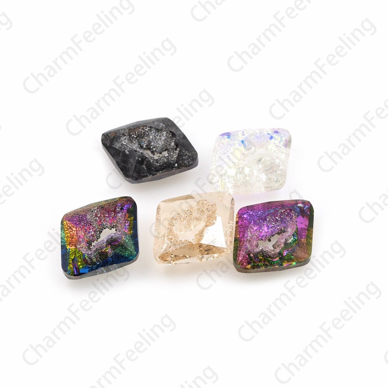 Puede incluir: Seis gemas de vidrio de forma cuadrada de diferentes colores con un dise&ntilde;o &uacute;nico, texturizado y cristalino. Las gemas son iridiscentes y presentan una variedad de colores, incluyendo negro, blanco, rosa, morado y marr&oacute;n.