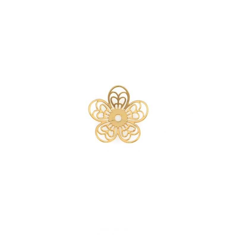 May include: Gold metal flower charm with a delicate, intricate design. The charm has a circular hole in the center for attaching to jewelry or other crafts.