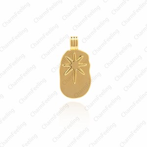 May include: Gold-toned pendant charm featuring a starburst design. The charm is shaped like a slightly irregular oval.