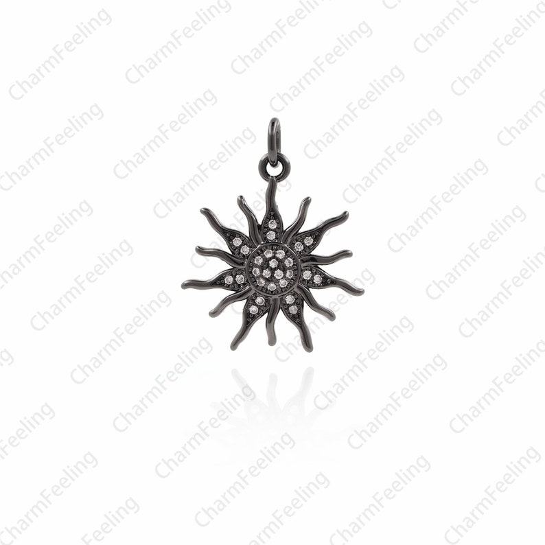 Puede incluir: Pendiente de sol negro con piedras de circonita c&uacute;bica transparentes. El dije tiene forma de sol con rayos que se extienden desde el centro. El dije est&aacute; hecho de metal y tiene un acabado negro.