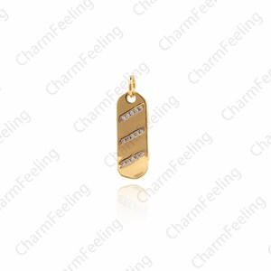 Op de afbeelding: Een gouden bedel met een rechthoekige vorm en een diagonaal patroon van kleine, heldere stenen.