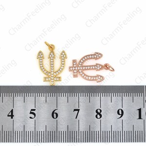 May include: Two gold and rose gold trident charms with clear rhinestones. The charms are approximately 1 inch in length and are measured on a ruler.