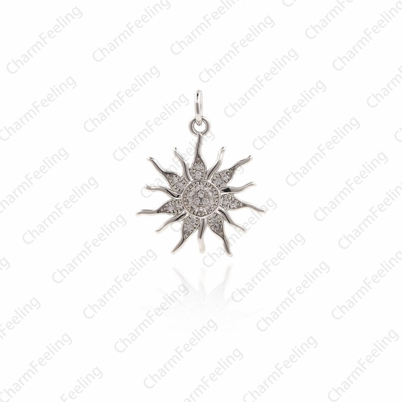 Puede incluir: Un colgante de sol de plata con piedras de circonita c&uacute;bica transparentes. El colgante est&aacute; detallado con un dise&ntilde;o de rayos de sol y es perfecto para agregar un toque de brillo a cualquier pieza de joyer&iacute;a.