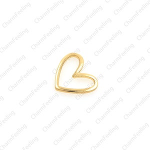 May include: A gold-colored metal heart charm with an open center. The heart is a simple design with a smooth finish.