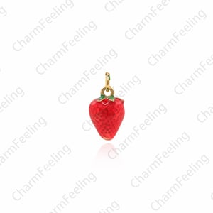 Puede incluir: Un charm de tono dorado con forma de fresa roja con hojas verdes. El charm est&aacute; detallado con una superficie texturizada y es perfecto para agregar un toque de fantas&iacute;a a las joyas.