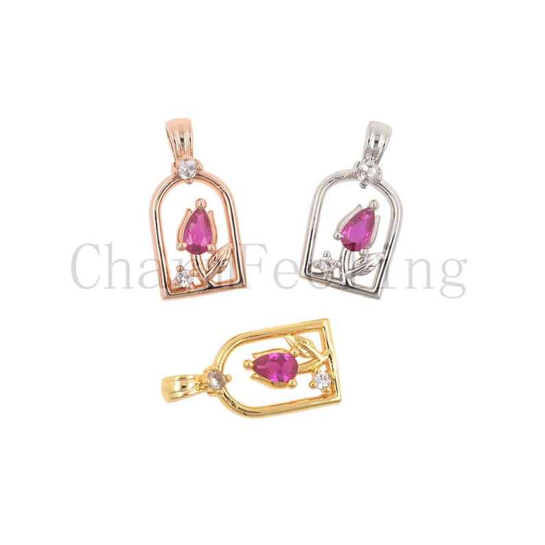 May include: Three rose charm pendants in gold, rose gold, and silver. Each pendant features a pink rose with clear crystal accents.