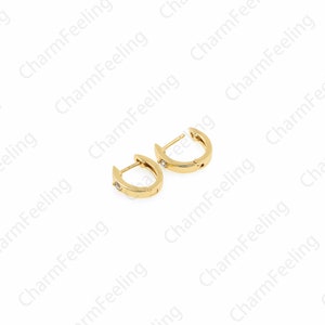 Peut inclure: Une paire de boucles d'oreilles cr&eacute;oles en or avec une petite pierre transparente sertie dans chaque cr&eacute;ole.