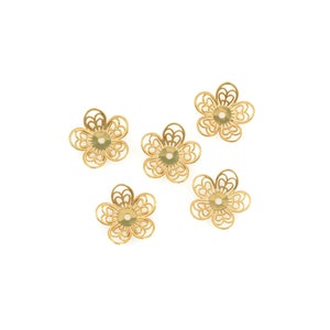 May include: Five gold-colored metal flower-shaped bead caps with a hole in the center.