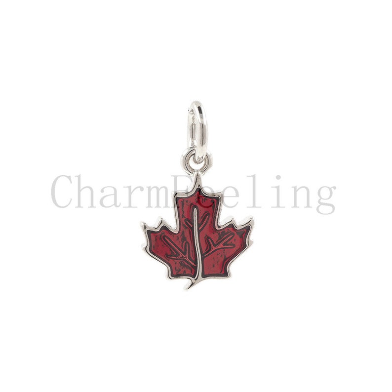 May include: A silver charm with a red enamel maple leaf design. The charm is perfect for adding a touch of Canadian pride to your jewelry.