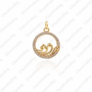 May include: A gold-toned pendant charm featuring a wave design with clear cubic zirconia stones. The pendant is circular and has a smooth, polished finish.