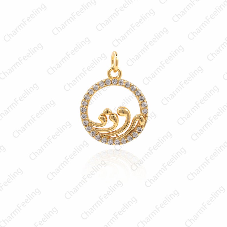 May include: A gold-toned pendant charm featuring a wave design with clear cubic zirconia stones. The pendant is circular and has a smooth, polished finish.