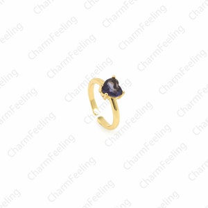 May include: A gold adjustable ring with a purple heart-shaped gemstone.