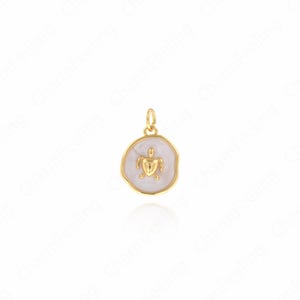 Peut inclure: Pendentif doré en forme de tortue sur fond blanc. La tortue est centrée sur un pendentif rond aux bords irréguliers. Le pendentif a une boucle en haut pour l'attacher à une chaîne ou un bracelet. Le pendentif est probablement en métal.