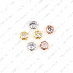 May include: Eight round metal beads with clear crystal accents. The beads are in three different metal finishes: silver, gold, and rose gold.