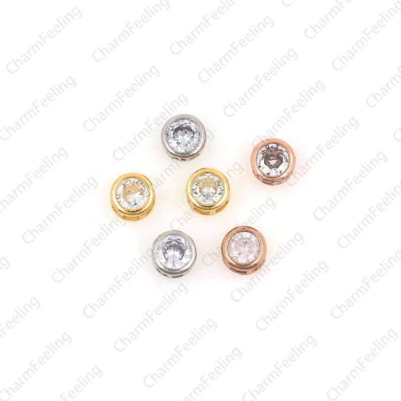 May include: Eight round metal beads with clear crystal accents. The beads are in three different metal finishes: silver, gold, and rose gold.