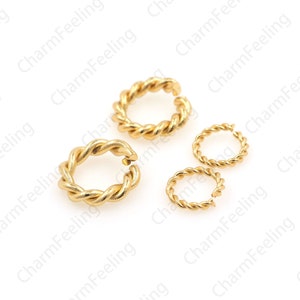May include: Three gold-coloured metal jump rings with a twisted rope design. The rings are different sizes.
