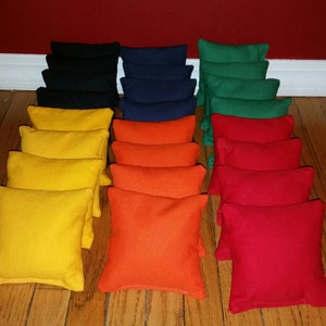 May include: A set of 20 bean bags in five different colors: yellow, orange, red, green, and blue. The bean bags are arranged in rows of four, with each row containing a different color.