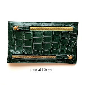 May include: Emerald green leather clutch with two gold zips. The clutch has a crocodile embossed pattern.
