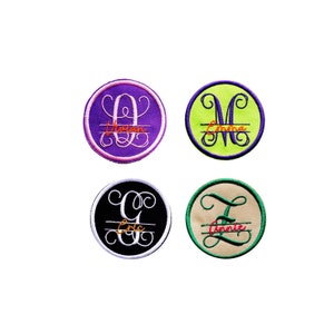 May include: Four round embroidered patches with a single letter in a cursive font and a name written below the letter. The patches are in different colors: purple, green, black, and beige.