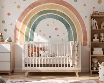 Könnte beinhalten: Ein weißes Kinderbett mit hellen Holzbeinen steht vor einer Wand mit einem großen Aquarell-Regenbogen-Wandbild und verstreuten Punkten. Der Raum enthält eine weiße Kommode, ein Holzregal mit Spielzeug und einen Teppich mit Stadtstraßen-Motiv.