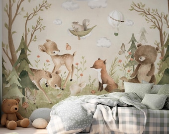 May include: A wall mural featuring a watercolor forest scene with a deer, a fox, a bear, and a squirrel in a leaf boat. The room includes a bed with a gray and white checkered comforter, green pillows, a gray rug, and two brown teddy bears.