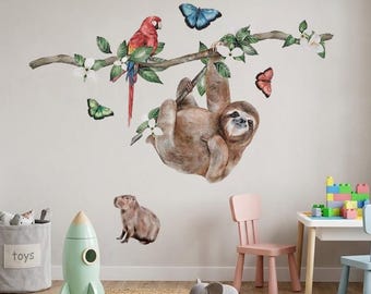 May include: A whimsical children's room scene featuring a wall decal of a sloth hanging from a branch with a parrot and butterflies. The room includes a toy rocket, a rocking horse, and a small table with chairs. A gray toy bin is also present.