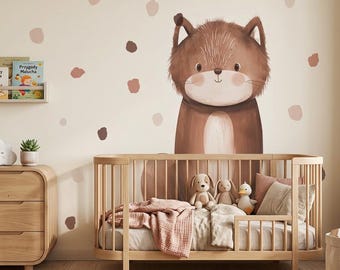 May include: A nursery scene featuring a wooden crib, dresser, and wall art. The wall has a large brown fox illustration and brown polka dots. The crib is filled with bedding and stuffed animals. A shelf holds books.