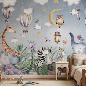 Puede incluir: Un mural de pared con una ilustración en acuarela de una jirafa, una cebra, un hipopótamo y un elefante entre plantas tropicales. El cielo incluye globos aerostáticos, nubes, estrellas, una luna creciente con un búho y farolillos colgantes.