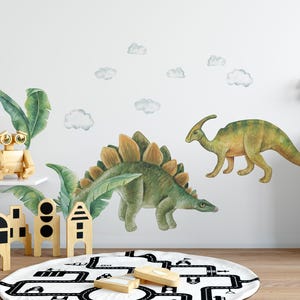 May include: Watercolor dinosaur wall decals in green and yellow, including a Stegosaurus and a Parasaurolophus. The decals are applied to a white wall with cloud accents. A wooden robot and other wooden toys are on a shelf.