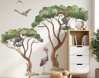 May include: Watercolor wall decals featuring toucans perched in leafy trees, a crowned crane, and flying birds. A wooden bookshelf with books and a teddy bear is next to the wall art. A woven rug and wooden toys complete the nursery decor.
