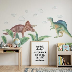 May include: A children's room scene featuring dinosaur wall decals, a wooden desk with a lamp, and a bookshelf. The wall art includes a Triceratops and a Spinosaurus. A framed quote in Polish is also visible.