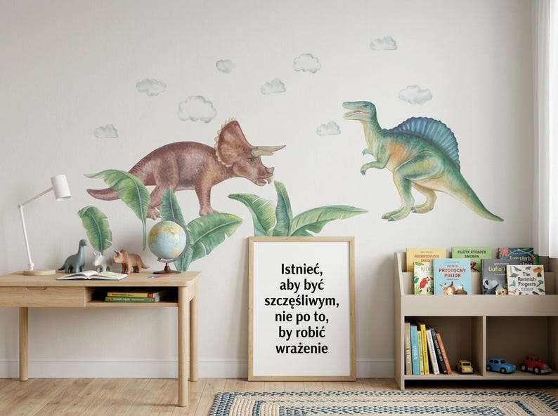May include: A children's room scene featuring dinosaur wall decals, a wooden desk with a lamp, and a bookshelf. The wall art includes a Triceratops and a Spinosaurus. A framed quote in Polish is also visible.