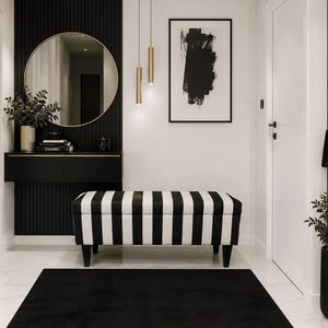 Può includere: Un ingresso moderno con una panca a righe bianche e nere, un tappeto nero e una consolle nera con uno specchio con cornice dorata. Un dipinto astratto in bianco e nero è appeso al muro e una borsa nera è appesa.