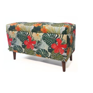 May include: A floral patterned storage bench with wooden legs. The fabric features a tropical print with green leaves, orange and yellow flowers, and red hibiscus flowers.