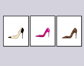 May include: Three framed prints of high-heeled shoes. The shoes are in different colors and patterns: black and white, pink, and leopard print.