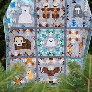 May include: A patchwork quilt with a variety of animal designs, including a polar bear, walrus, owl, musk ox, and a pair of otters. The quilt is made with a variety of fabrics in shades of blue, brown, gray, and white.