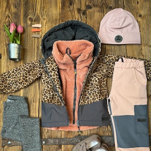 Può includere: Un set di abbigliamento per bambini in stampa leopardata, rosa e grigio. Il set include una giacca, pantaloni, leggings, un cappello e scarpe.