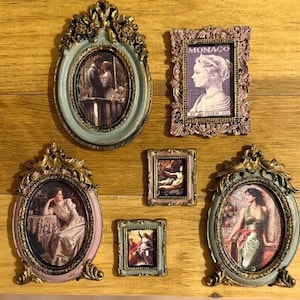 May include: Collection of ornate vintage-style picture frames in various shapes and sizes. The frames feature gold accents and hold images of classical art and portraits. The color palette includes shades of green, pink, and gold.