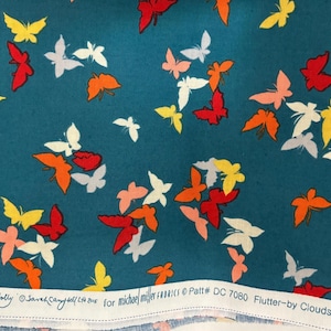 Könnte beinhalten: Türkisfarbener Stoff mit einem sich wiederholenden Muster aus bunten Schmetterlingen in Rot, Orange, Gelb, Weiß und Rosa. Der Stoff hat Text am unteren Rand, der lautet: "SexTolly © Sarah Campbell/Clouds for michael miller fabrics Patt# DC 7080 Flutter-by Clouds".