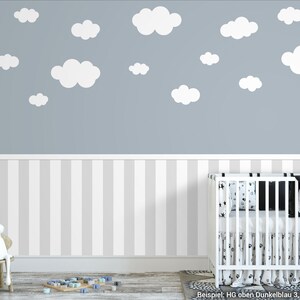 May include: A nursery room with a white cot, a white chair with a stuffed rabbit, and a grey wall with white cloud decals. The wall is also decorated with a white and grey striped wallpaper.