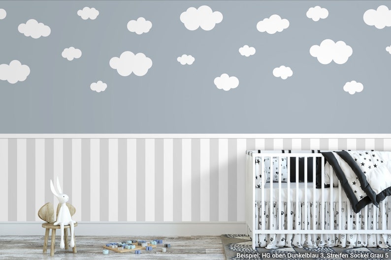 May include: A nursery room with a white cot, a white chair with a stuffed rabbit, and a grey wall with white cloud decals. The wall is also decorated with a white and grey striped wallpaper.