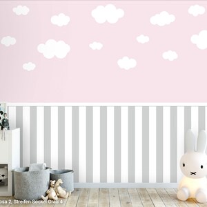 May include: A pink and grey striped wallpaper with white clouds. The wallpaper is ideal for a nursery or child's room. The wallpaper is shown in a room with a white dresser and a white rabbit lamp.