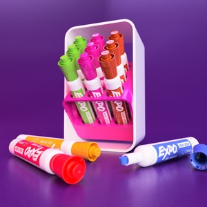 May include: A pink and white marker holder with a variety of colored Expo brand dry erase markers. The holder has a slot for each marker and is designed to hold them upright. There are several markers lying on a purple surface.